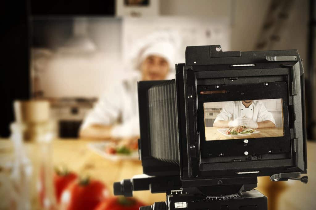 young cook and camera in studio