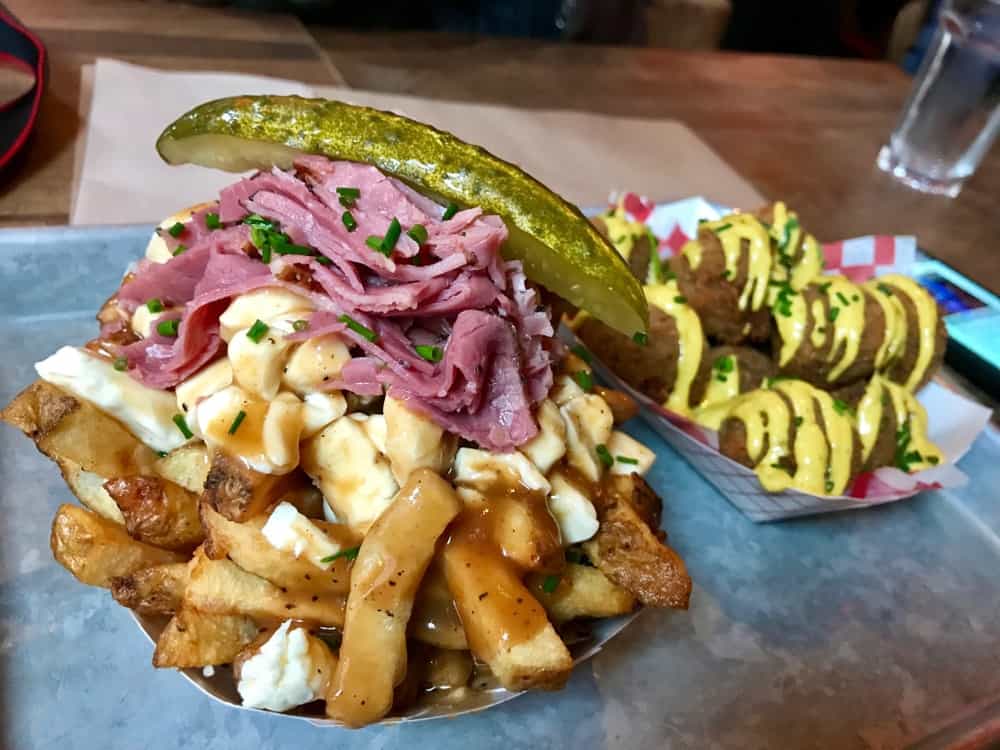 Bar Food - Classic poutine served in a Quebec local bar. Fries, cheese curds, meat and pickles with gravy.