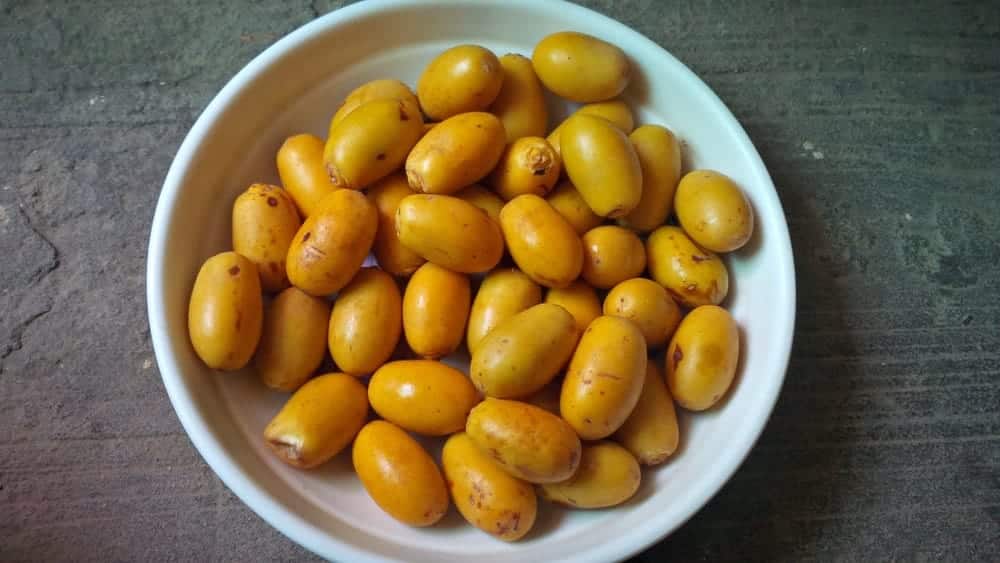 Un plato lleno de frescos y crujientes Dátiles Barhi.