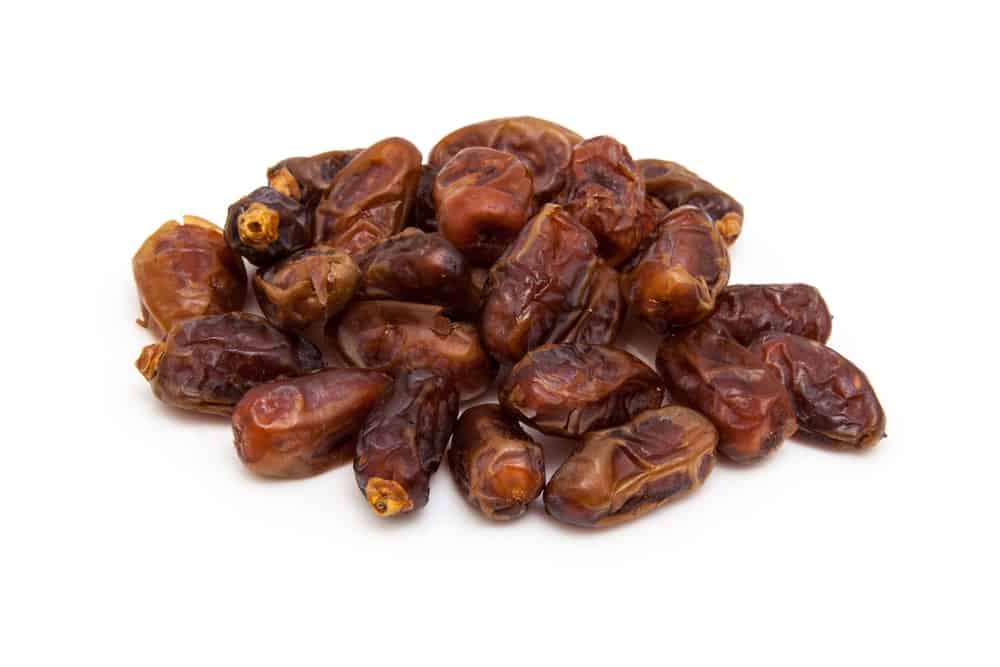 A bunch of dried Halawy Dates on a white background.