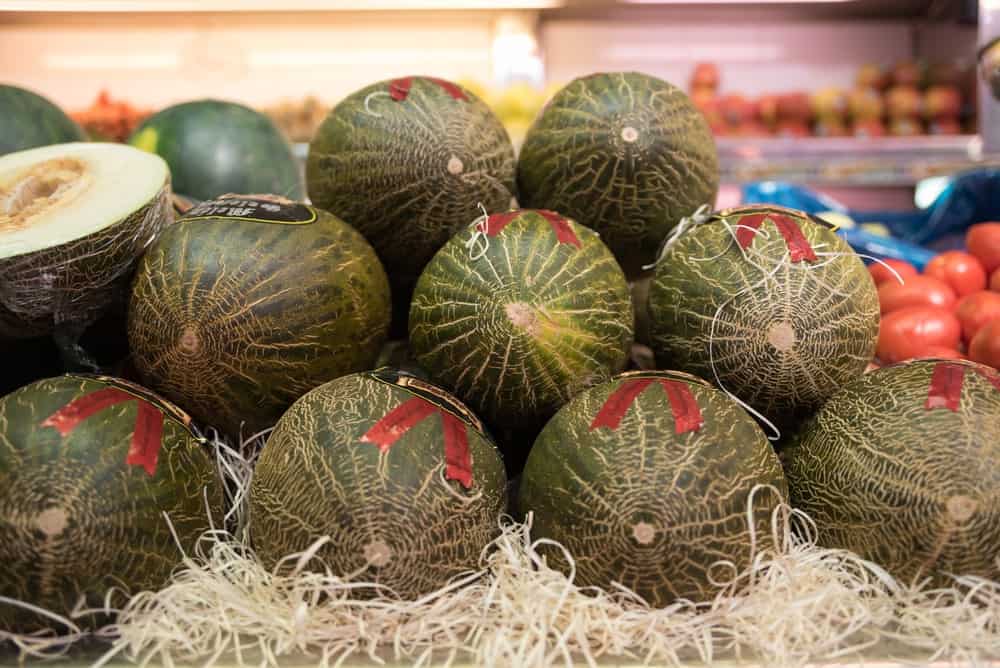 A bunch of Valencia Melons for sale in the market.