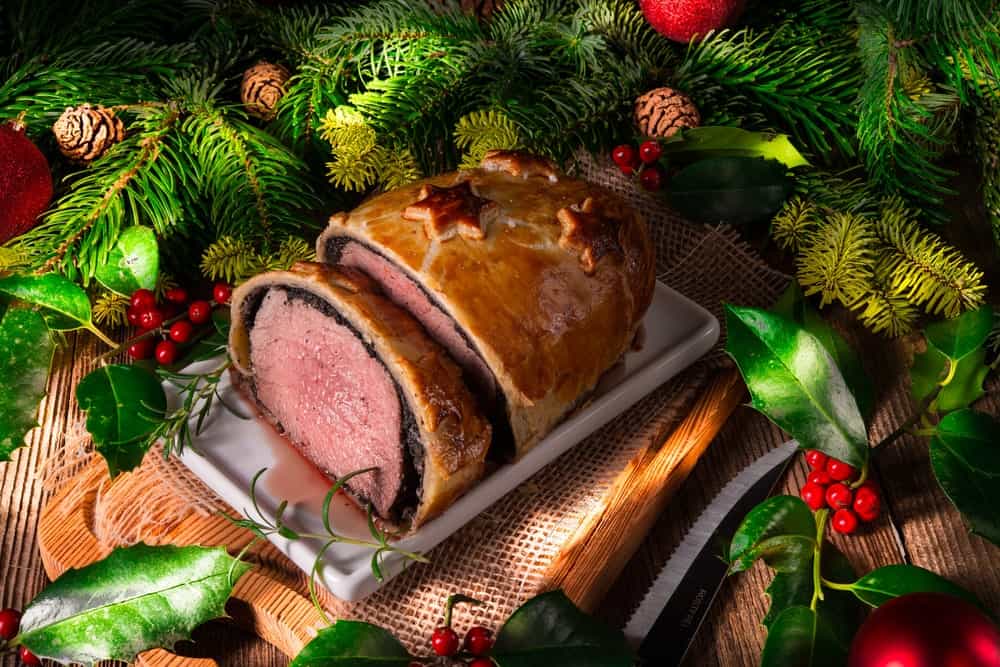 Beef Wellington surrounded by Christmas decorations.