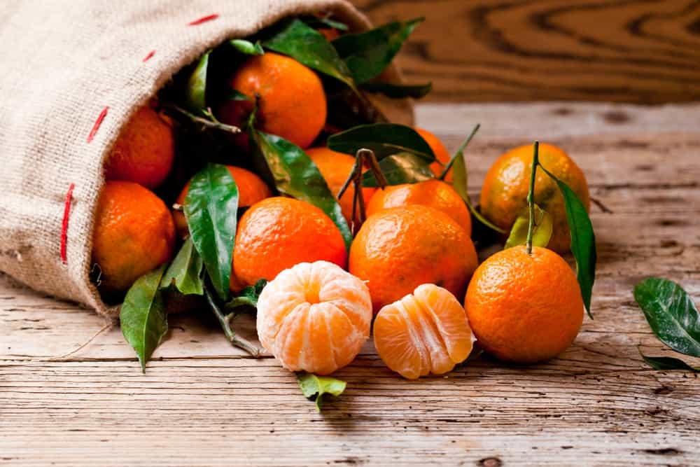 Mandarins spilled from a sack.