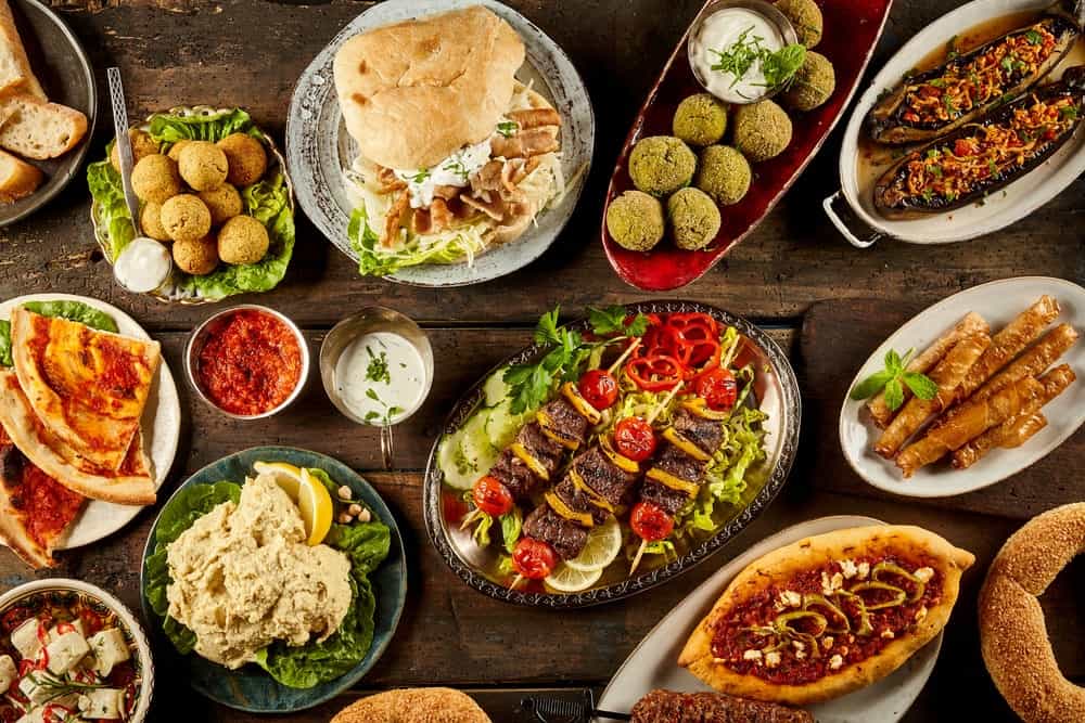 A variety of delicious dishes on a wooden desk.