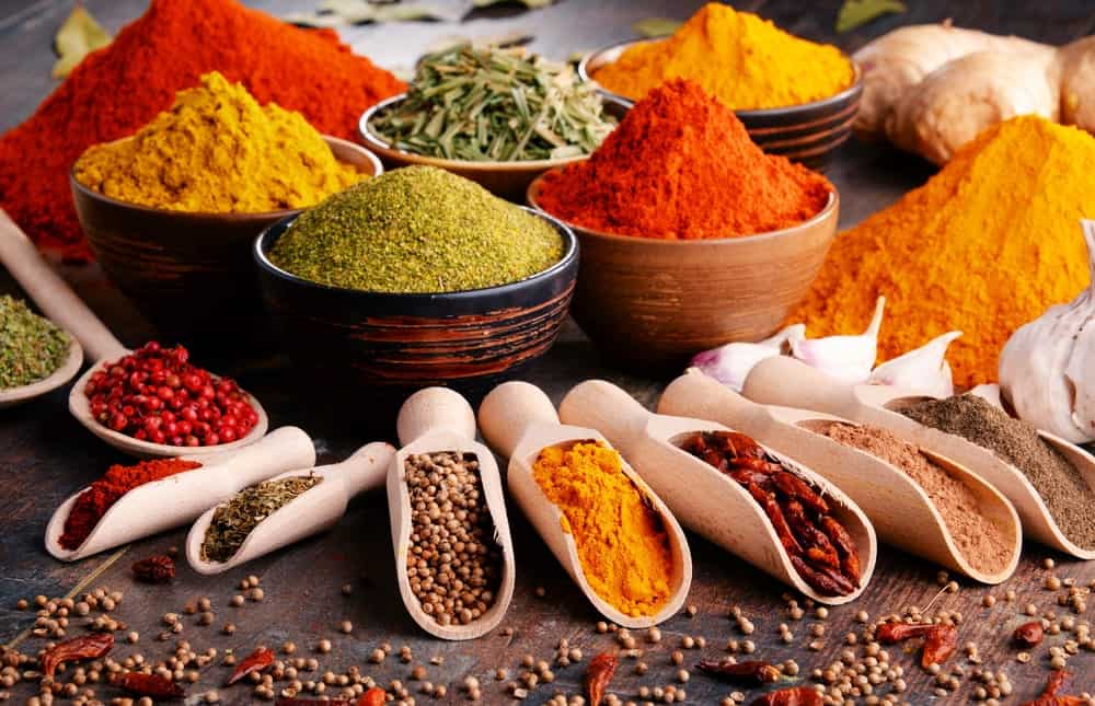 Bowls and spoons of various spices on the table