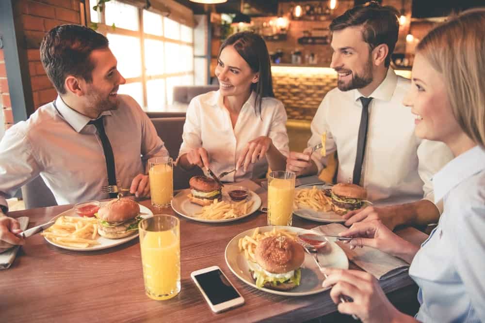 A group of men and women eating in a sit down restaurant