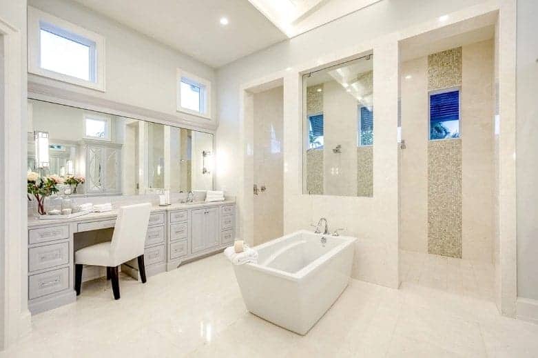 This primary bathroom is the perfect blend of simplicity and contemporary elements with the standing bathtub in the middle and wooden vanity cabinetry.