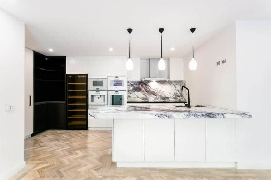 Spruce up your kitchen with the refreshing combination of marble countertop and faux wood flooring. Finish it off with a white pendant lighting for a classy touch.