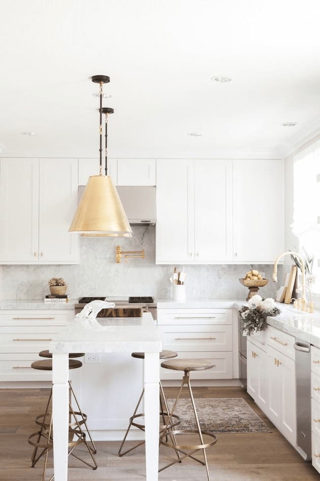 Go for a sophisticated touch in your kitchen with the perfect combination of white cabinetry and bronze bar stools for that subtle pop of color. It would also help to achieve a classy look with a brass pendant lighting, even a brass faucet and drawer handles.
