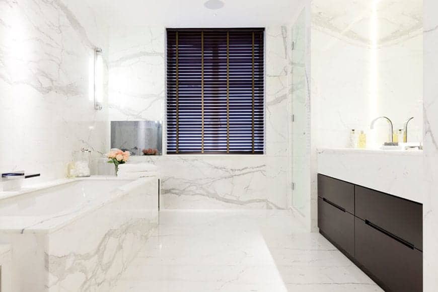 The white primary bathroom features marble vanities on both sides. Primary bath has the sophistication and detail that only show up in the most luxurious of dwellings.