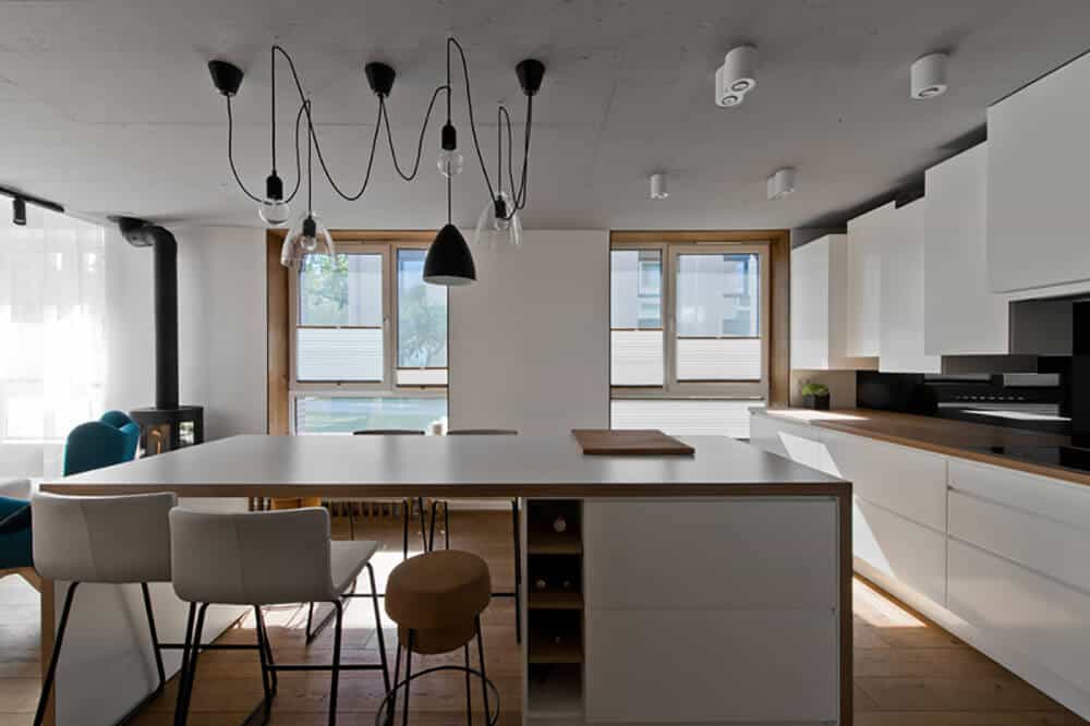 For more Asian kitchen inspiration, take some pointers from this design with its simplistic white and wooden kitchen counter and dining table. Its wide glass windows provide a beautiful sunray during the day, which is also great for cutting power cost short. This kitchen has a good mix of pendant lighting and recessed lights.