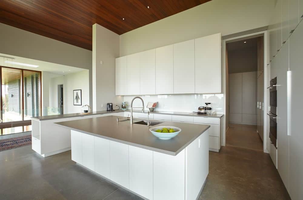For an urban kitchen, this one has a great mix of white and steel, with the L-shape bar and island white and only the countertops being steel.