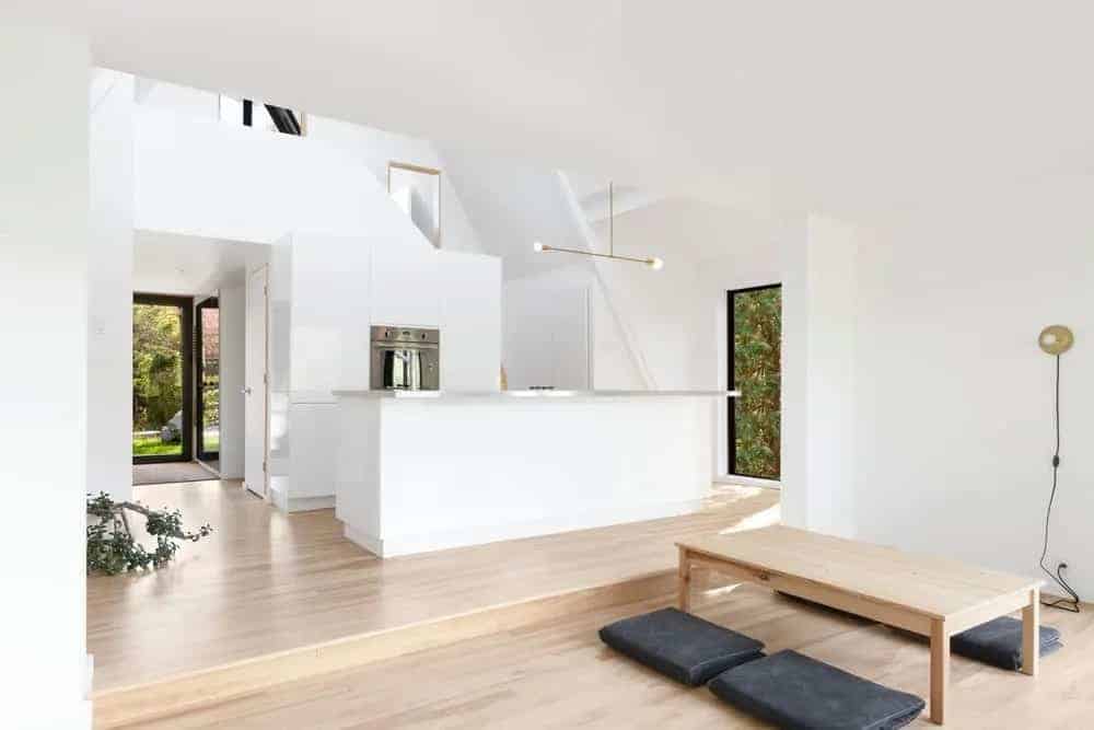You can't go wrong with a beige and white combination if you're looking to build a simple and minimalist home kitchen, whilst entering a tasteful glass door. With the Japanese aesthetics in mind, this kitchen has a kotatsu (low, wooden table) in place with charcoal futons on each side for you and your guests. Cap it off with unique hanging lighting with the same minimalist design.