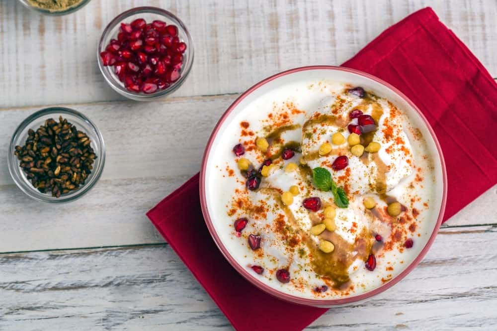 A delicious bowl of Indian dahi bhalla or dahi vada filled with nuts and spices.