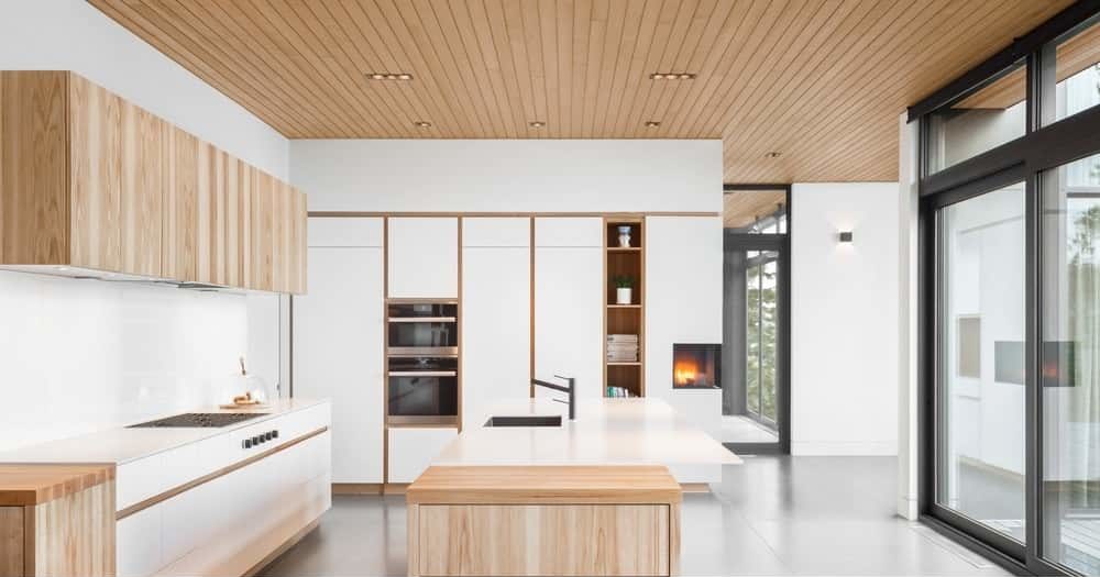 For an Asian inspired kitchen, take inspiration from this style. It shows a fine and simplistic design for fuss-free cooking. It features plain white shelves with wooden partitions, as well as a wooden aesthetics for the pantry and the additional drawers beside the kitchen counters, that also play out as sidebars.