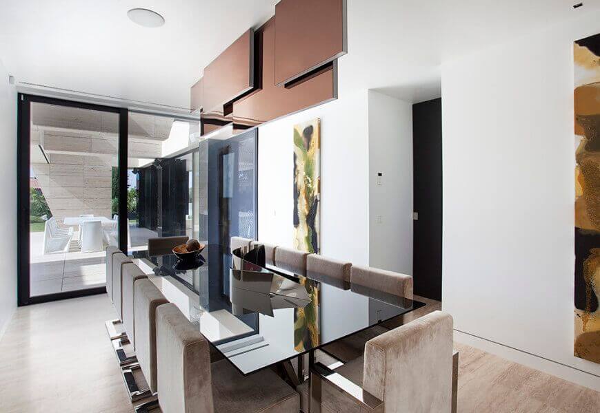 The modern house featuring a glass dining table set with modern chairs. This room also has white walls and great wall decors.