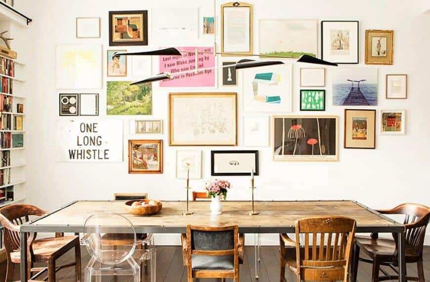 A classy dining area highlighting various wall designs and bookshelf. It also features wooden rectangular tables and various chairs.