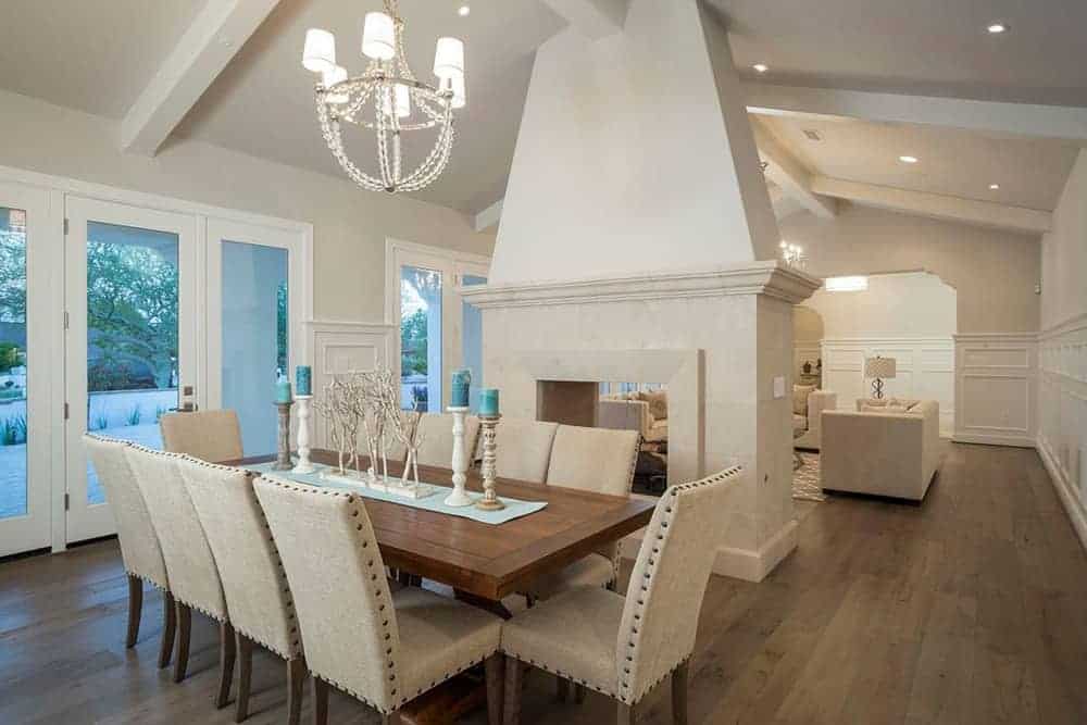 Classy dining area featuring wooden tables with brown chairs in front of the glass door with a beautiful view outside.