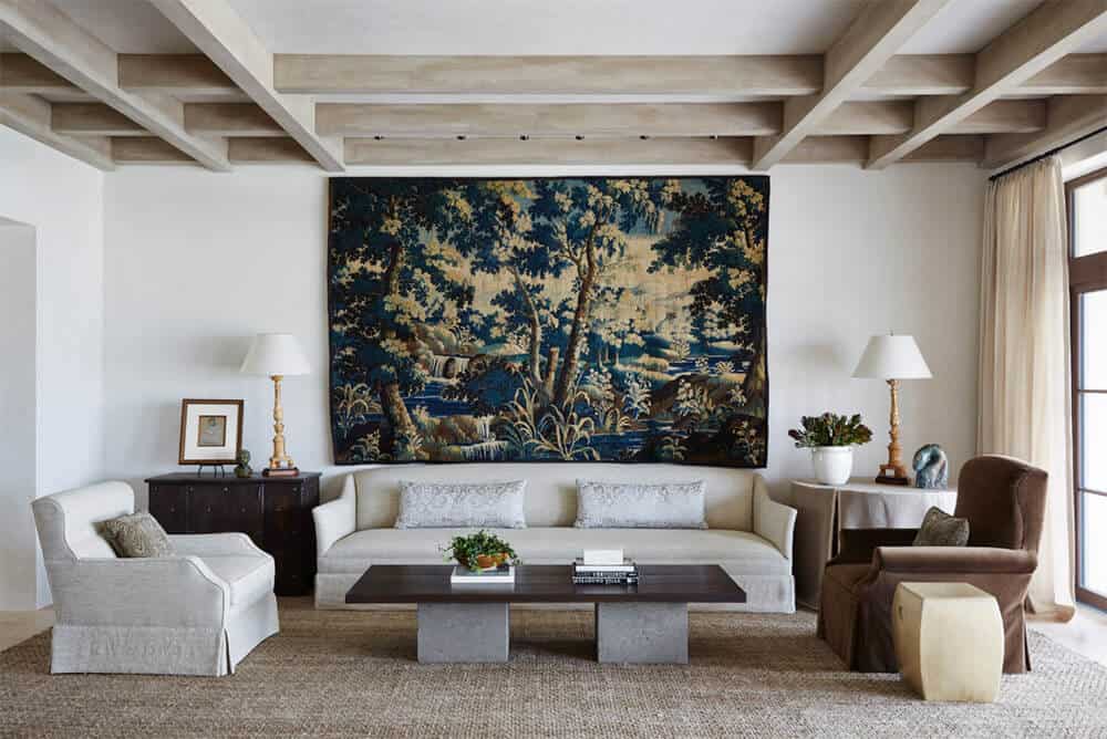 This formal living room highlighting a white wall with elegant decor and a gorgeous couch on the rug. The ceiling with exposed beams looks appealing as well.