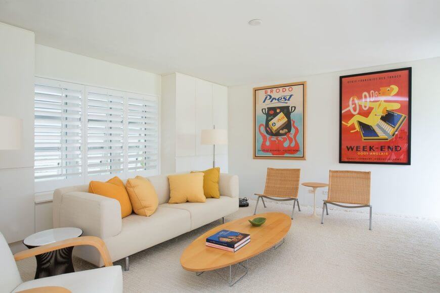 A simple living area with a comfy couch set on the rug flooring along with beautiful wall decors.