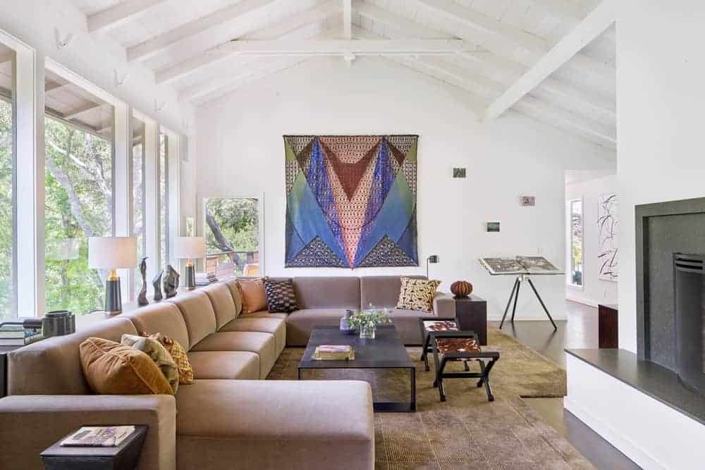 This formal living space promoting a great design of the sofa set on the top of a stylish rug under the arched ceiling with beams.