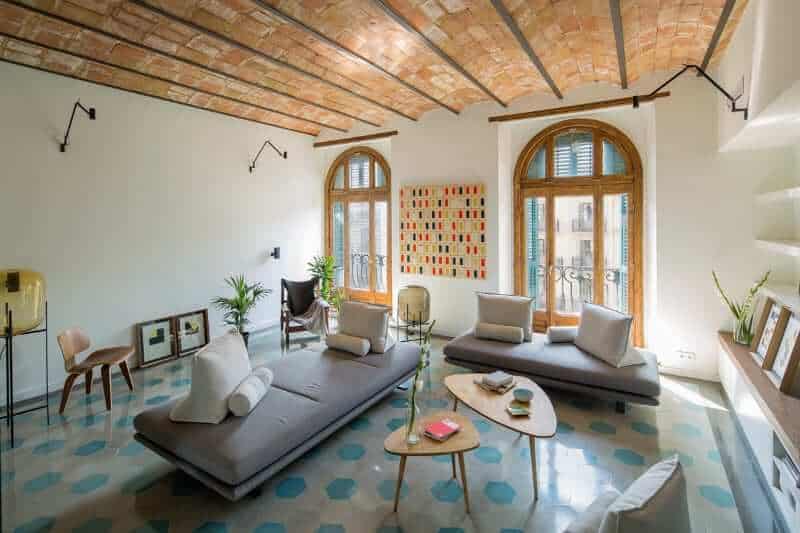 A classy small living space with a gorgeous ceiling and white walls, along with polished flooring.