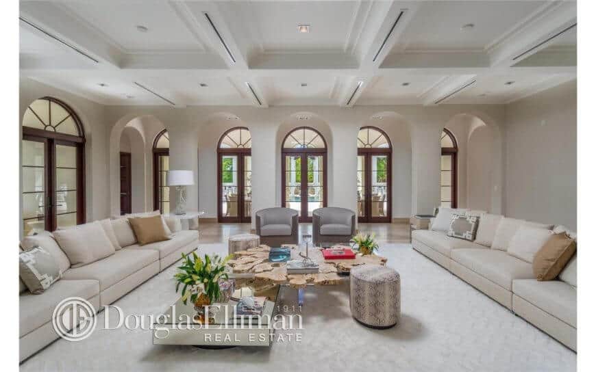 Contemporary home offering a huge formal living room with an exquisite couch set on a white floor covering. The dazzling roof with its lighting looks amuses as well.