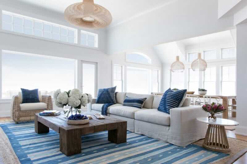Bright living room with a stylish sofa set design with a wooden table on the rug. This room has huge window and a great overlooking view.