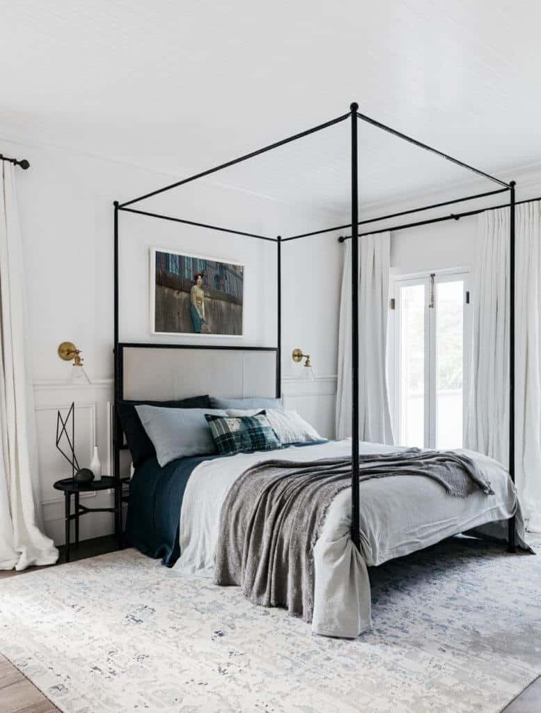 A direct shot at this master bedroom's sleek bed set with a nice painting and edgy bed frame on the carpet topped on the room's hardwood flooring.