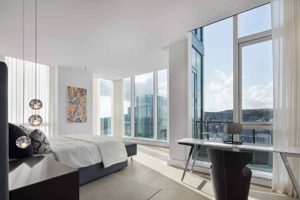 This master bedroom with white walls and ceiling along with a stylistic wall decor and pendant lights.