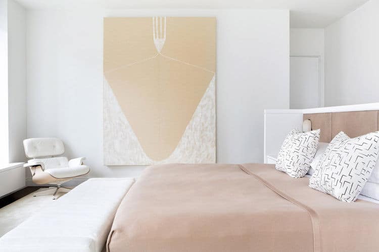 This master bedroom featuring white walls and ceiling. It also features huge wall decor that looks gorgeous.