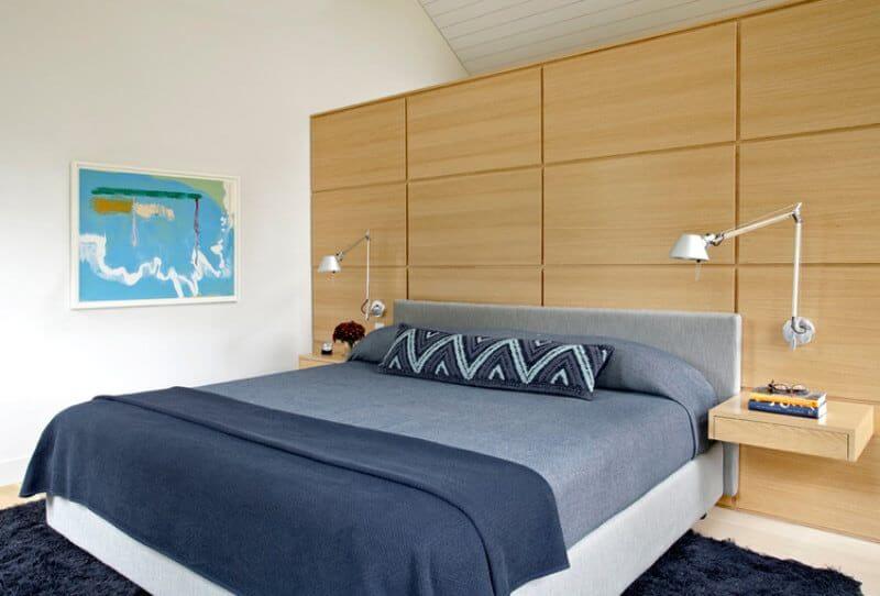 A close up look at this master bedroom's large comfy bed with a build-in side table on both sides.