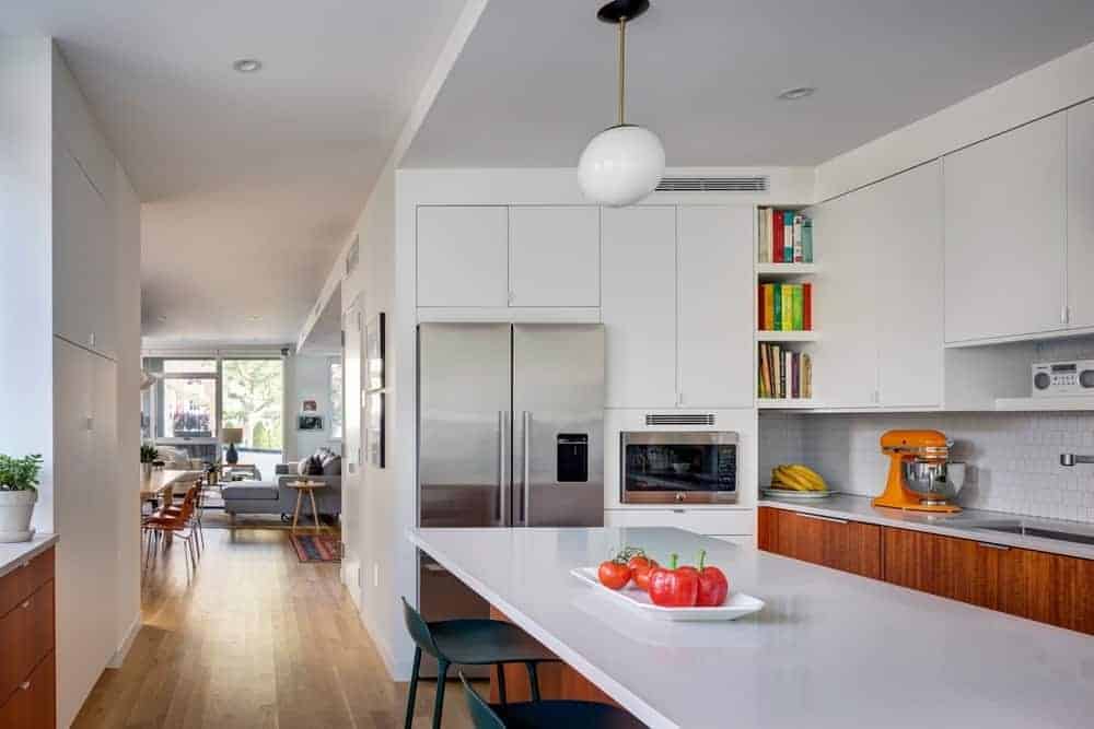 This kitchen has a great modern design with its white furniture, long peninsula, and generous cupboard. It has a tiny space for a kitchen but which makes a nice room for intimate dinners. There's also bar stools ready for kitchen guests during taste tests.