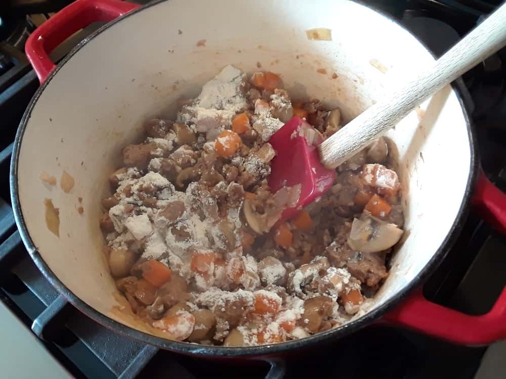 The pan of onion, mushroom, carrots and meat with a dash of flour.