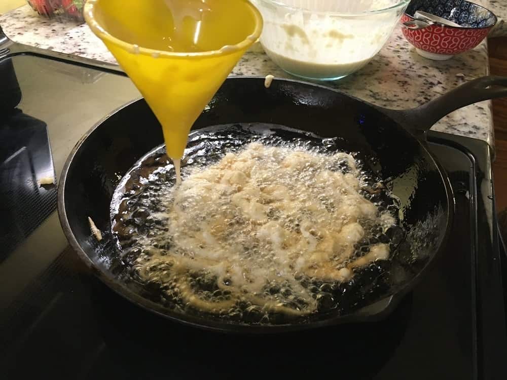 The mix is shaped into a round patty in the oil.
