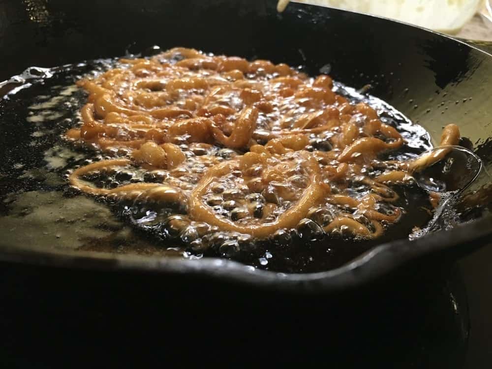 A close up of the funnel cake when it is fully brown in the oil.