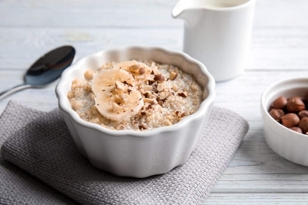 A bowl of quinoa porridge with banana and nuts.