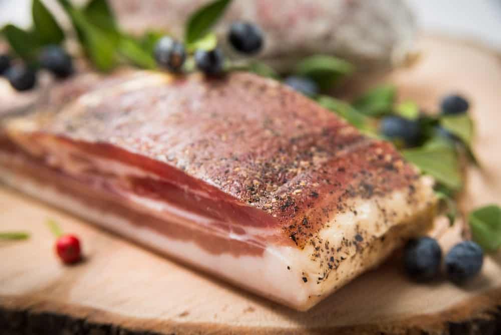 A slab of jowl bacon with spices.