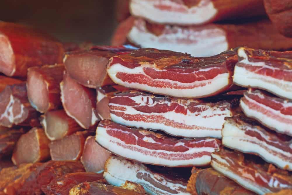 Stacks of cured bacon and smoked meat.