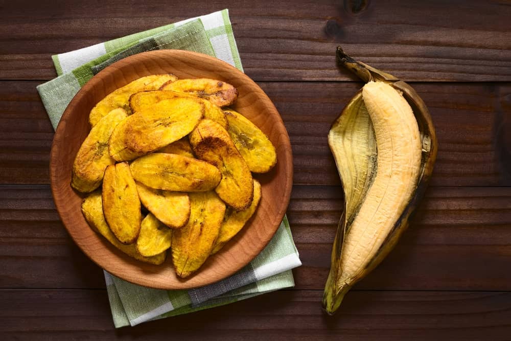 A wooden plate of fried plantains.