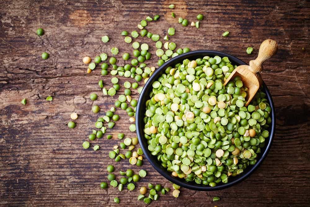 A look at a bowl of green and yellow split peas.