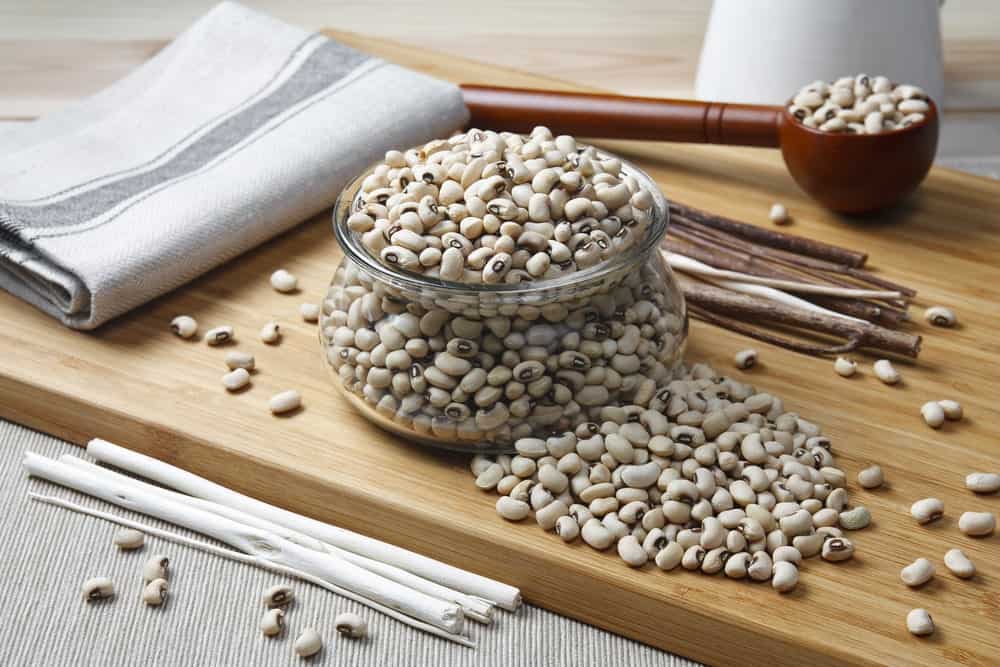 A jar of Navy beans on a chopping board.