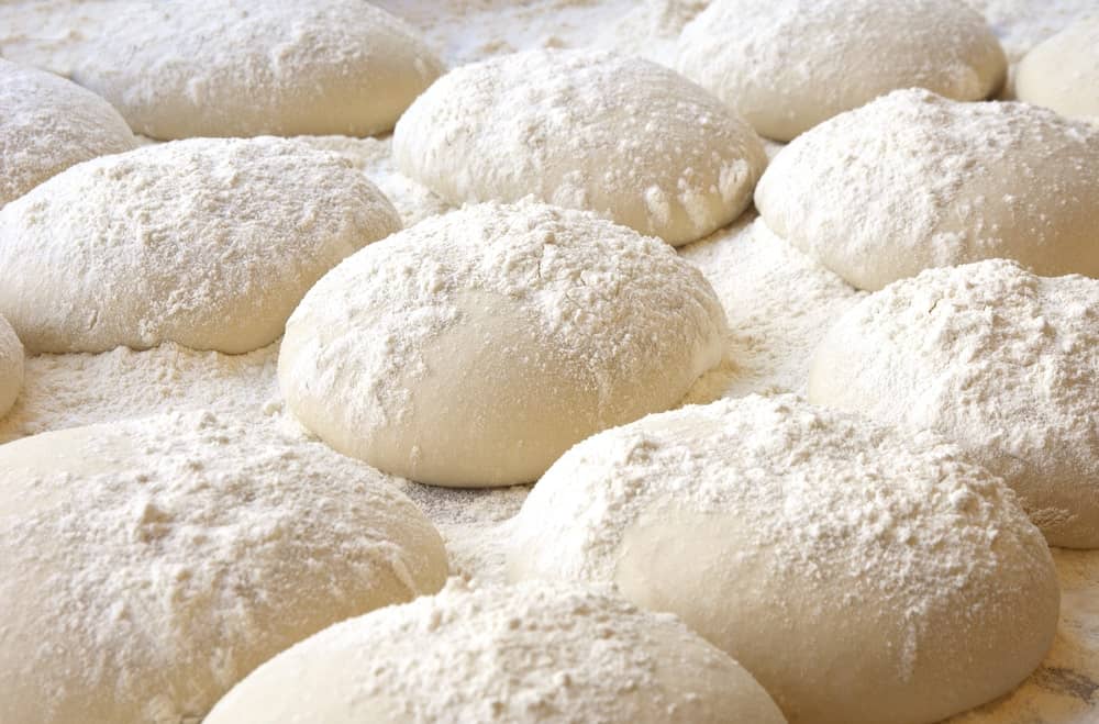 Balls of dough covered with flour ready to be baked.