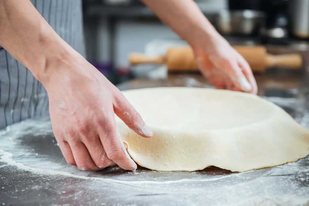 A look at a non-laminated pie dough being prepared on the pan.