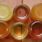 Different varieties of honey in separate glass jars.