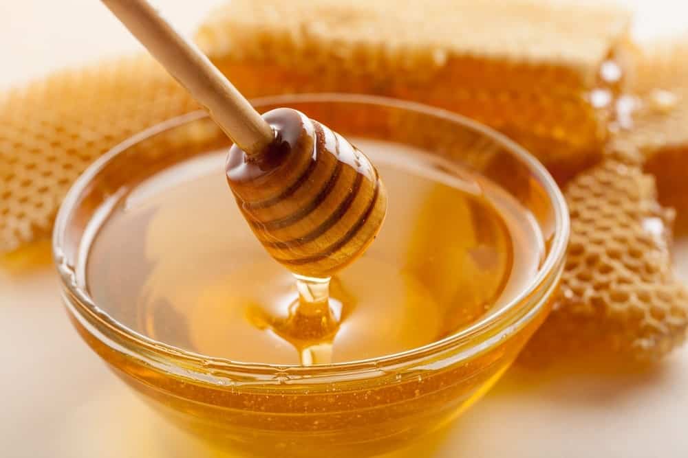 A glass bowl of liquid honey.
