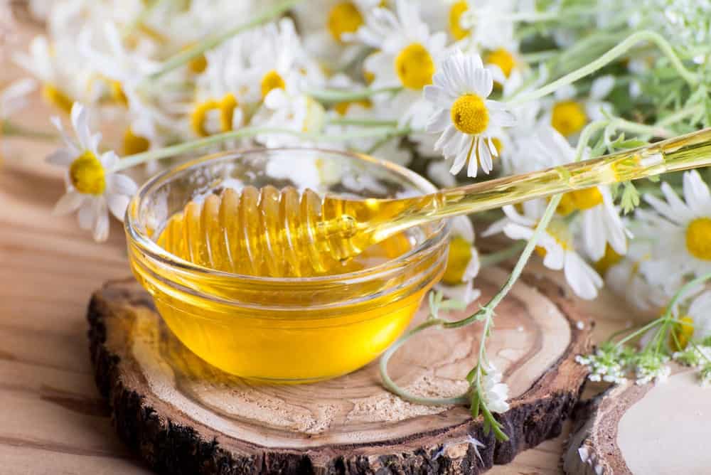 A glass bowl of spring herbal honey.
