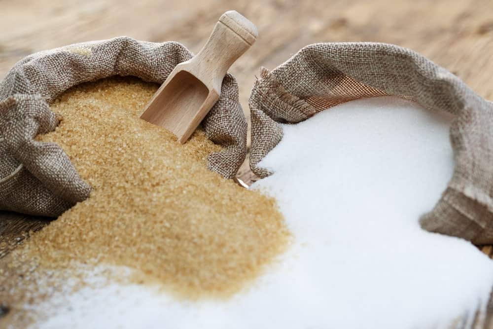 A sack of brown sugar and a sack of white sugar.