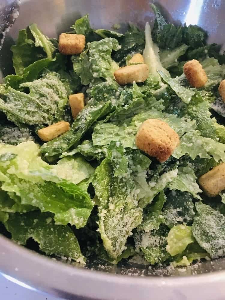 A bowl of freshly-made Caesar salad with croutons.