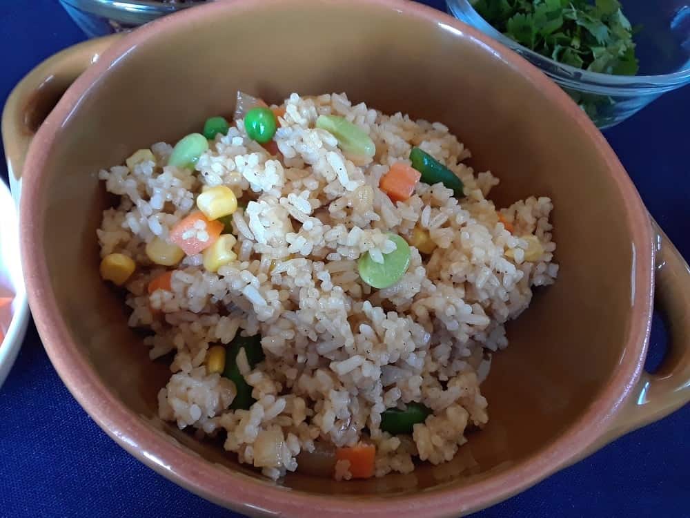 A close look at a bowl of freshly cooked vegan fried rice.
